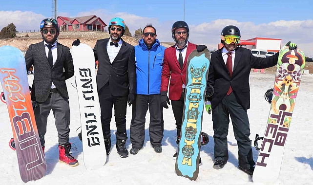 Kayak sezonunu takım elbiseyle snowboard yaparak uğurladılar