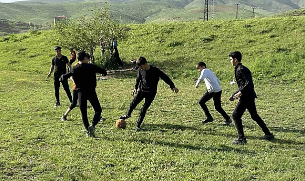 Hakkari'de boş arazide kıran kırana top oynayan gençler futbol sahası istiyor