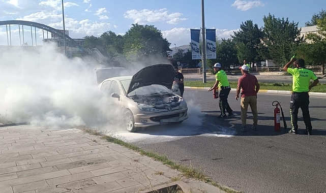 Erzincan'da yanan otomobili trafik polisleri yangın tüpüyle söndürdü