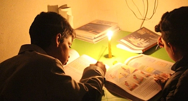 Öğrenciler mum ışığında ders çalışıyor